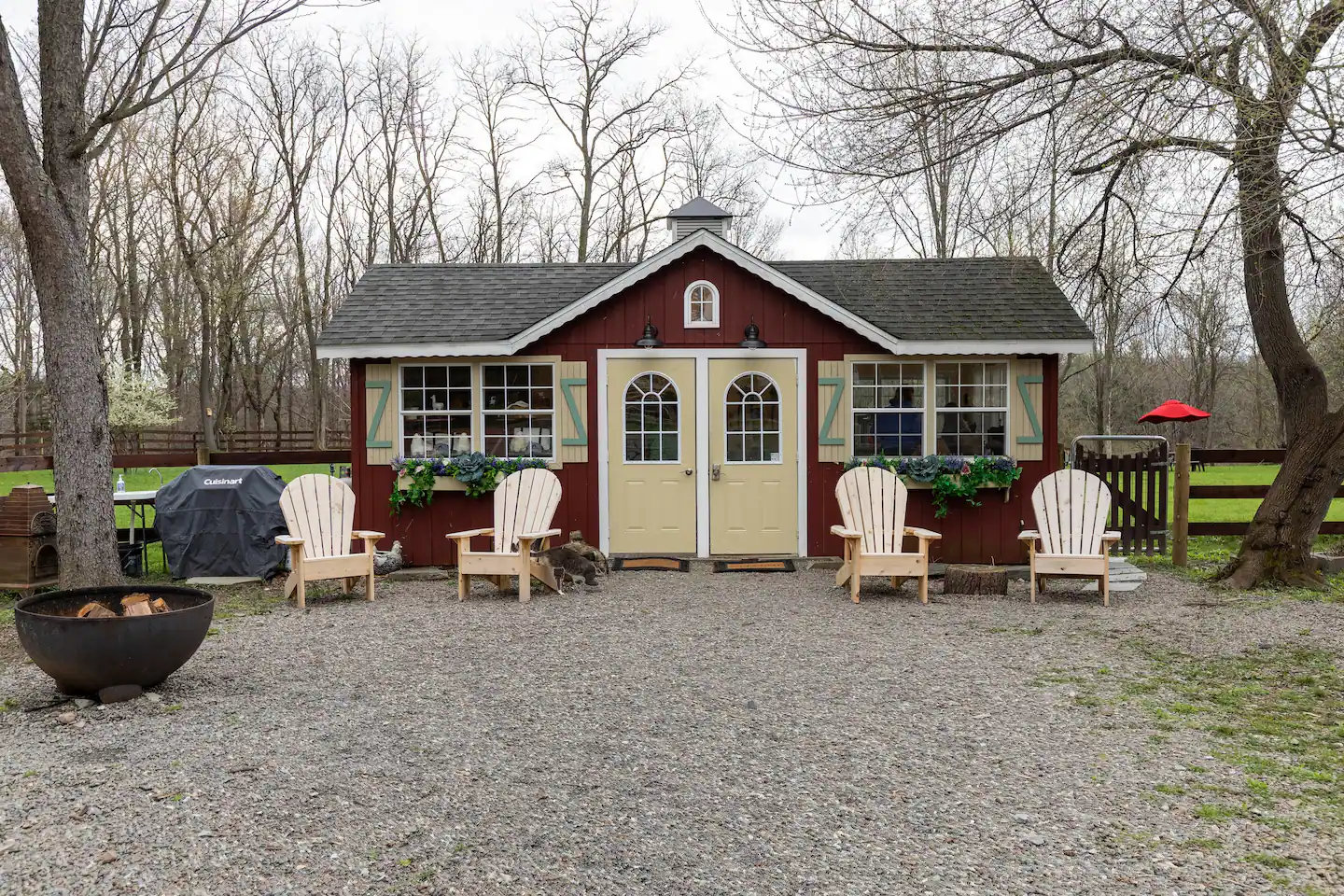 Red-and-white outbuilding with outdoor chairs