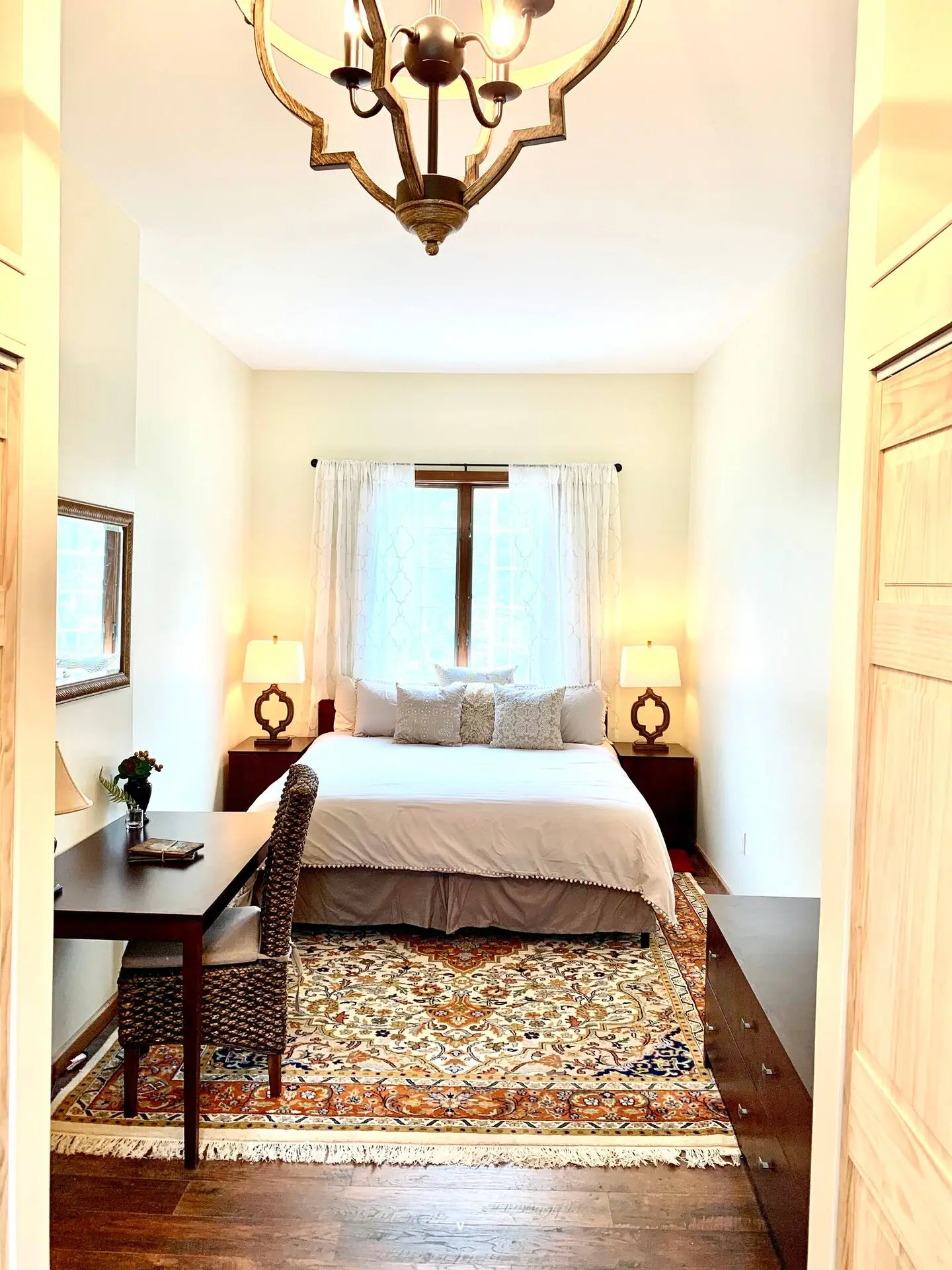 Bedroom with a chandelier, desk, and king-size bed