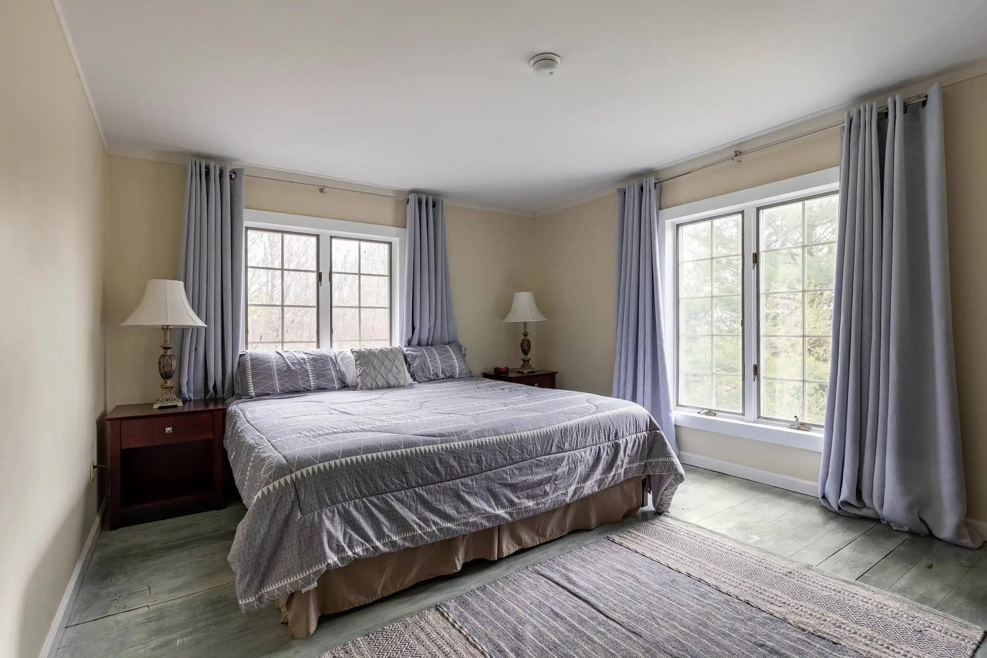 Bedroom with a king-size bed and windows overlooking the property